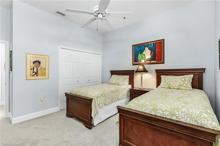 Bedroom with a closet, light carpet, and a ceiling fan