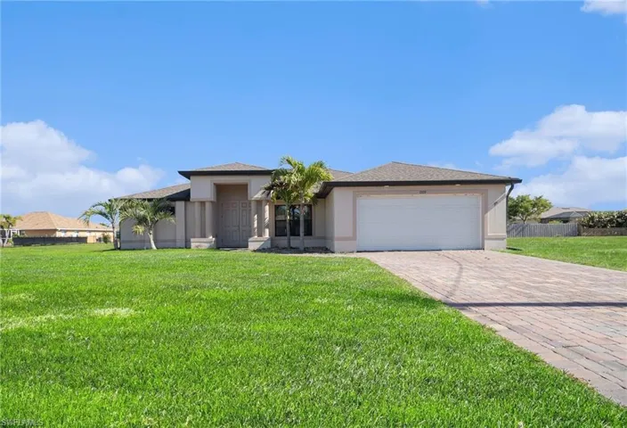 View of front of house with decorative driveway, roof with shingles, a garage, and stucco siding