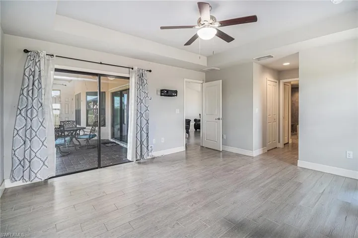 Empty room featuring tile wood-style floors, ceiling fan, recessed lighting, and a raised ceiling