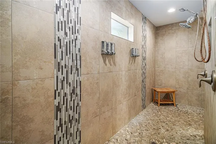 Full bath with tiled shower and recessed lighting