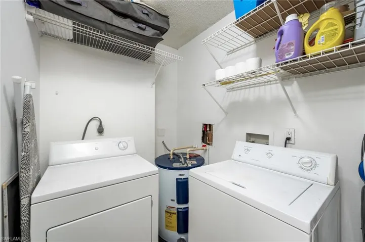 Laundry area with water heater, a washing machine, and a dryer