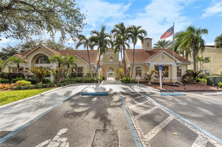 View of clubhouse exterior featuring uncovered parking
