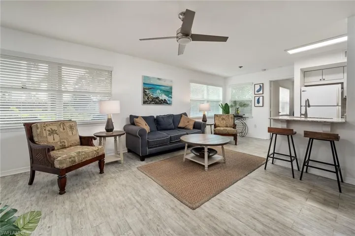 Living area with ceiling fan and light finished floors