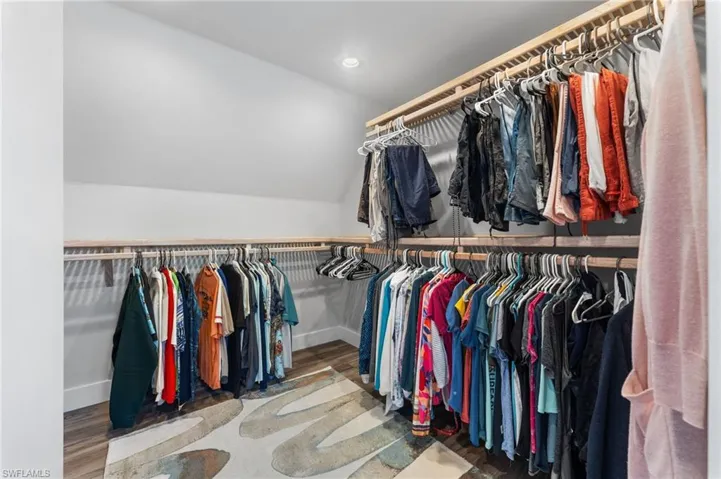 Walk in closet with vaulted ceiling and wood finished floors