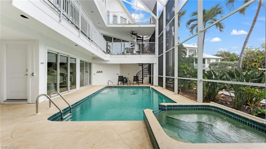 View of swimming pool, with connected hot tub, a patio, and stairs