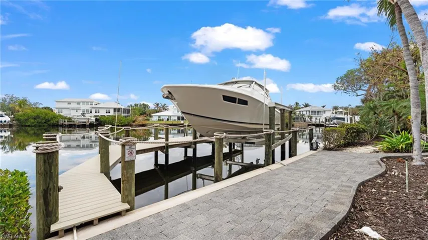 Dock area featuring boat lift and a water view