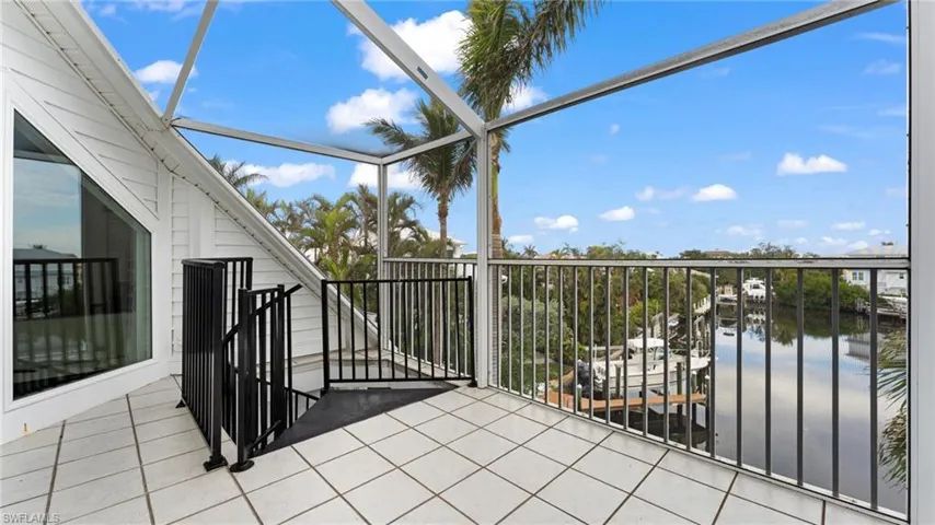 Balcony featuring a sunroom and a water view