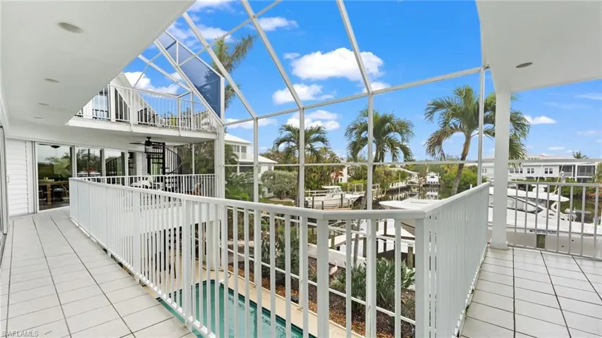 Balcony with a sunroom, a water view, and view of pool area