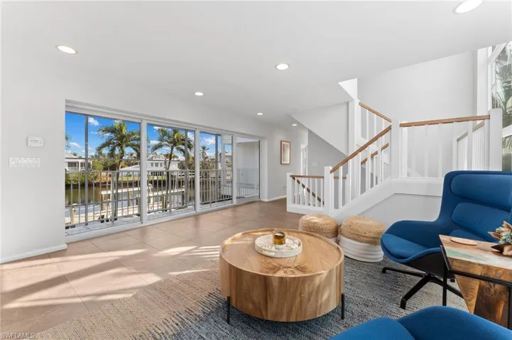 Sitting room featuring stairs, recessed lighting, a water view, and tile patterned flooring