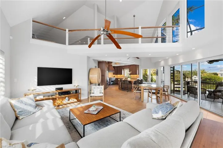 Living room with high vaulted ceiling, ceiling fan, and recessed lighting