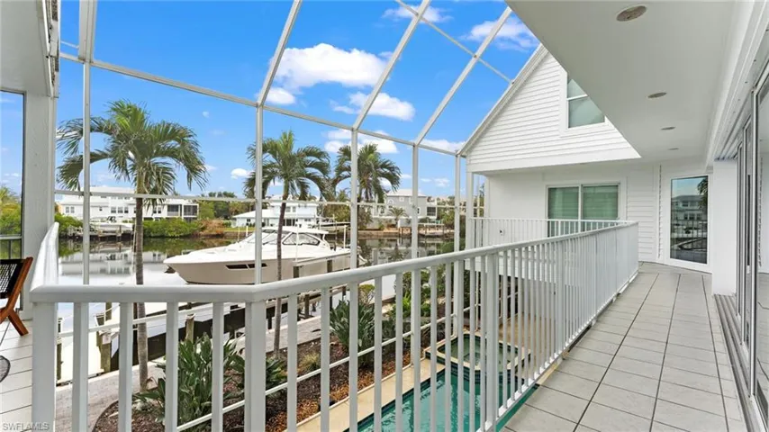 Balcony featuring a water view, a sunroom, and view of pool