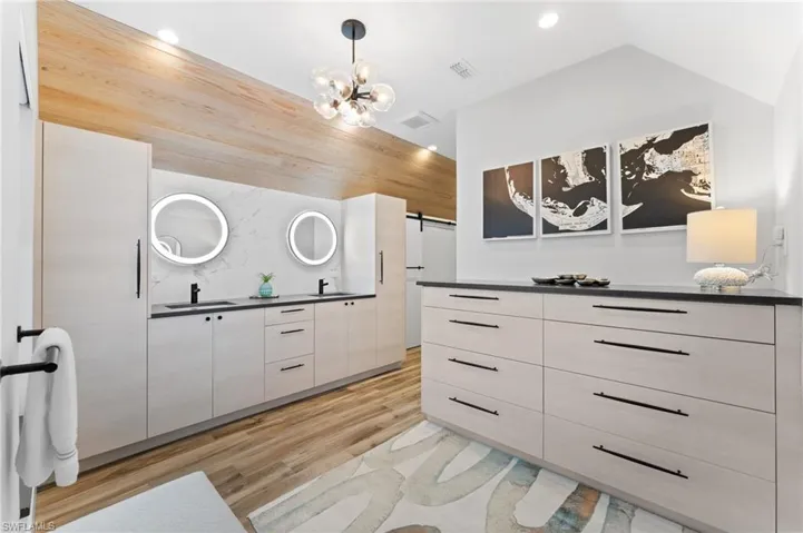 Full bathroom with double vanity, light wood-type flooring, and recessed lighting