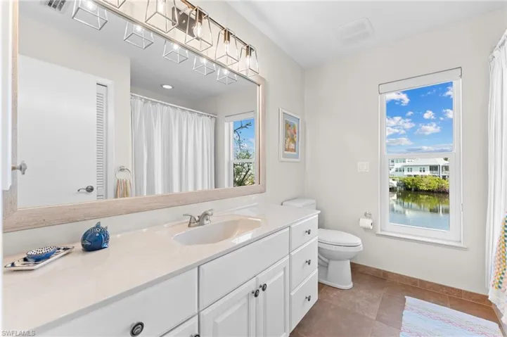 Full bath with vanity, a shower with shower curtain, and dark tile patterned flooring