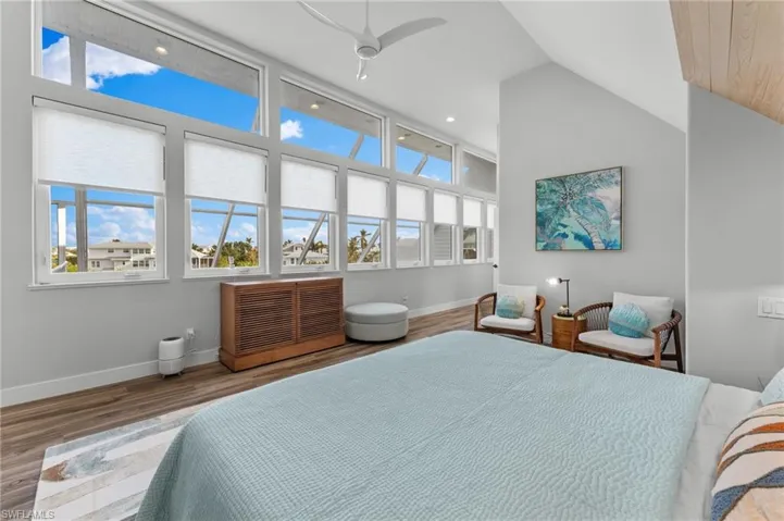 Bedroom with wood finished floors, vaulted ceiling, recessed lighting, and ceiling fan