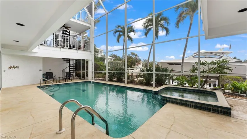 View of swimming pool featuring a patio, a lanai, a sunroom, and a pool with connected hot tub