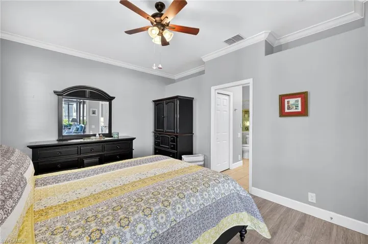 Bedroom with light wood-type flooring, crown molding, and ceiling fan
