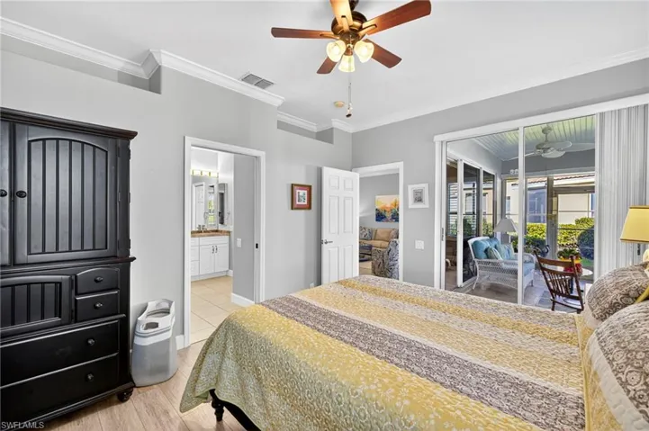 Bedroom featuring ornamental molding, access to outside, a ceiling fan, light wood-style flooring, and ensuite bathroom