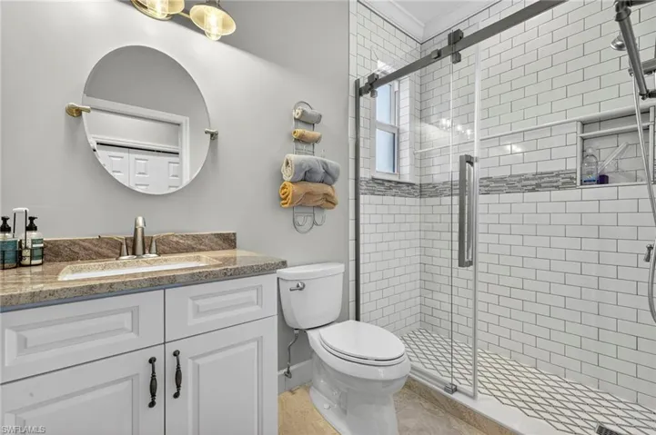 Bathroom featuring vanity, a shower stall, and crown molding
