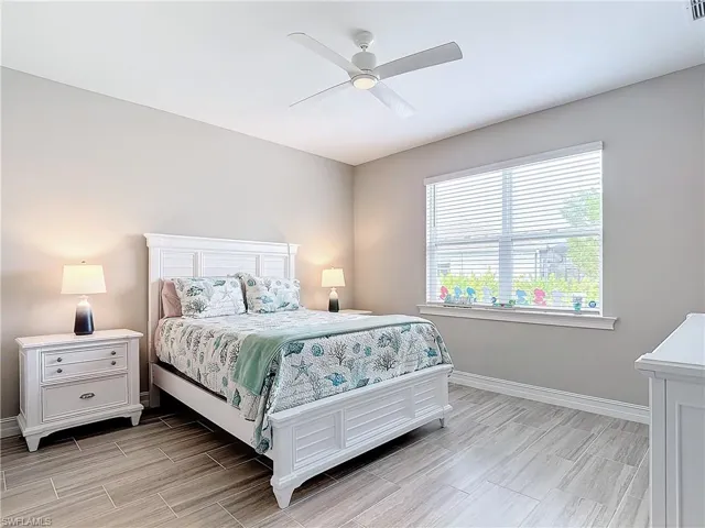 Bedroom featuring wood finish floors, baseboards, and ceiling fan