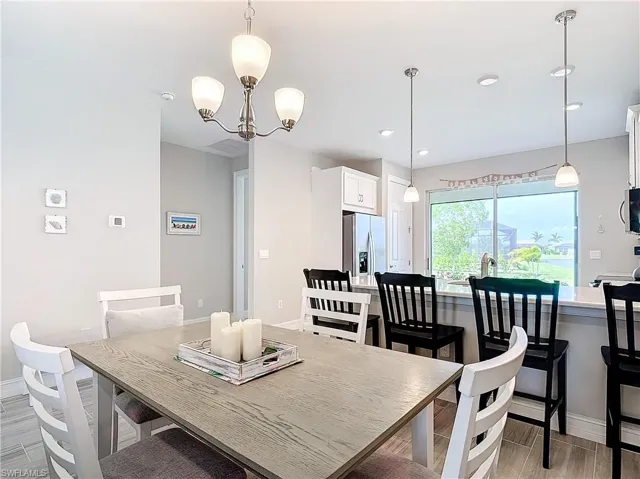 Dining space with baseboards, a chandelier, light wood finished floors, and recessed lighting