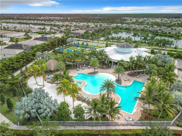 Aerial perspective of suburban area with a pool area and a nearby body of water