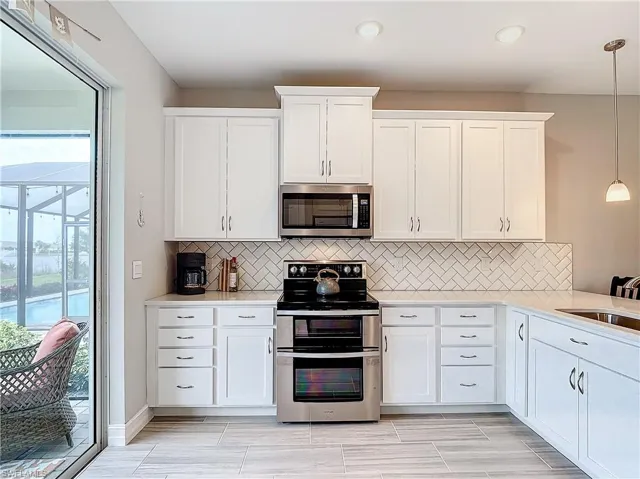 Kitchen featuring appliances with stainless steel finishes, healthy amount of natural light, light countertops, and backsplash