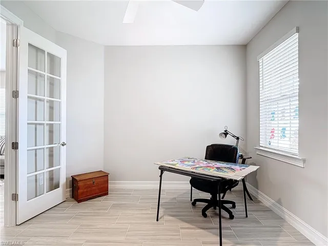 Office space featuring ceiling fan, healthy amount of natural light, baseboards, and wood finish floors