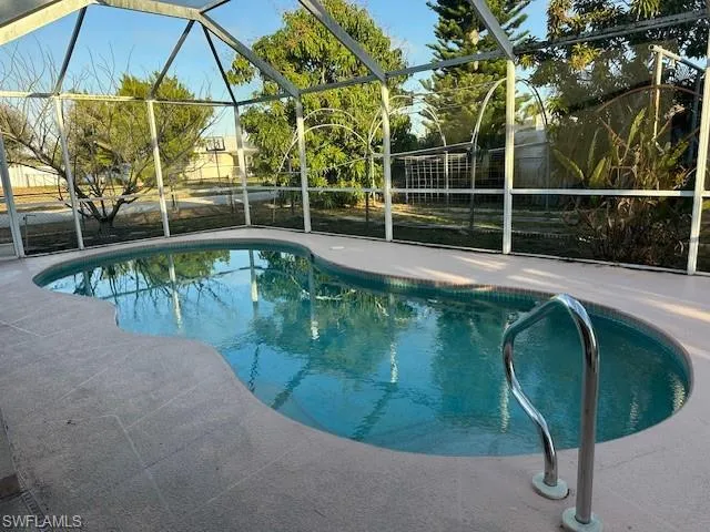 Outdoor pool with a sunroom and glass enclosure