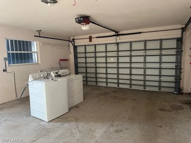 Garage featuring separate washer and dryer and a garage door opener