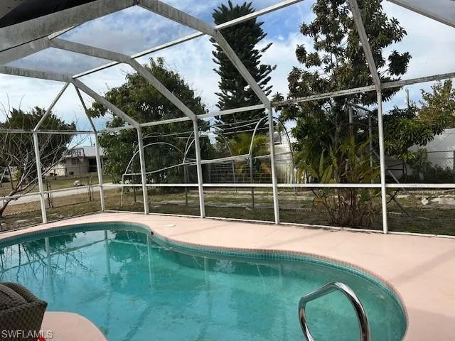 Outdoor pool featuring a sunroom and glass enclosure
