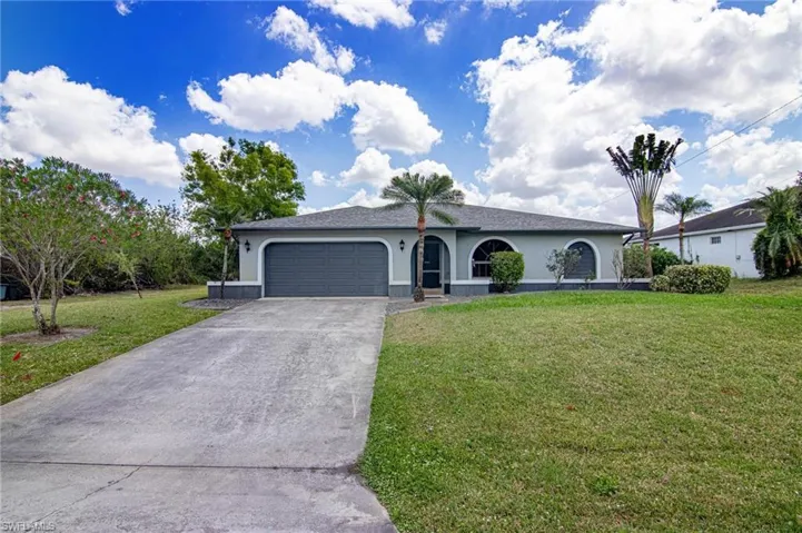 Ranch-style house with a garage, stucco siding, concrete driveway, and a front yard