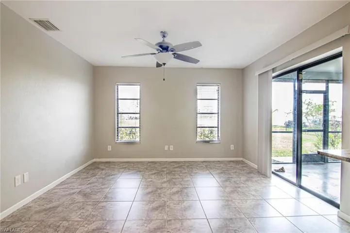 Spare room featuring visible vents, baseboards, a ceiling fan, and a healthy amount of sunlight