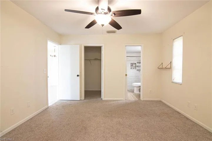 Unfurnished bedroom with visible vents, baseboards, connected bathroom, and carpet
