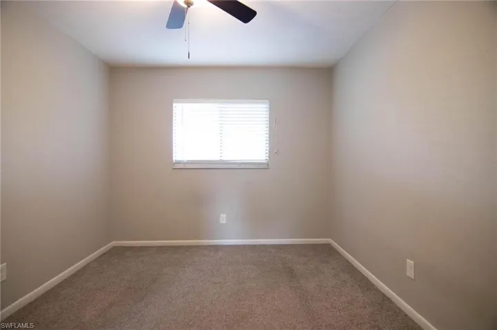 Spare room with carpet, baseboards, and ceiling fan