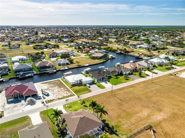 Aerial perspective of suburban area featuring a nearby body of water