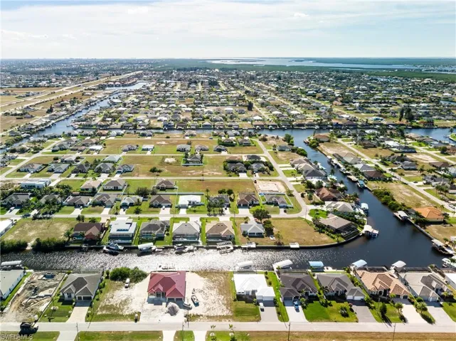 Aerial view of property's location with nearby suburban area and a nearby body of water