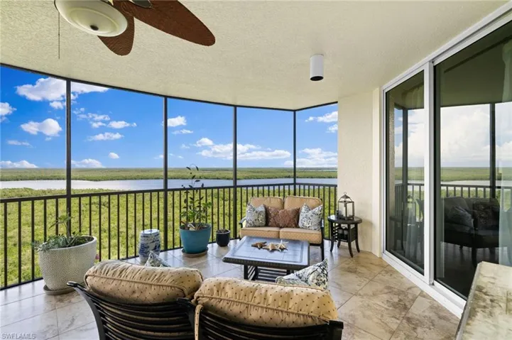 Sunroom / solarium with a water view, ceiling fan, and a wealth of natural light