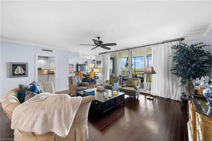 Living room with ornamental molding, french doors, dark hardwood / wood-style flooring, and ceiling fan