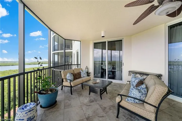 Sunroom / solarium featuring ceiling fan and a water view