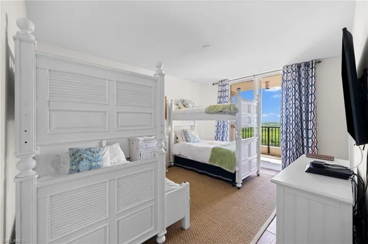 Bedroom with a wall of windows and access to outside