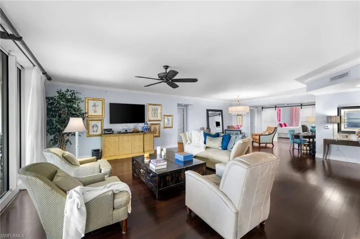Living room featuring crown molding, ceiling fan, and dark hardwood / wood-style floors