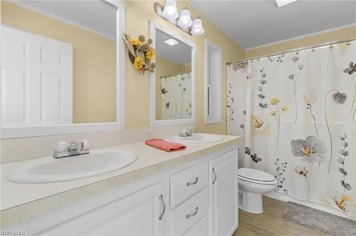 Bathroom with wood-type flooring, toilet, curtained shower, a textured ceiling, and vanity