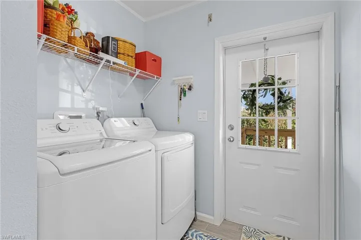 Laundry area featuring ornamental molding and separate washer and dryer