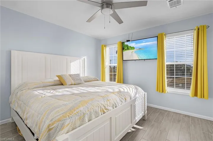 Bedroom featuring multiple windows, light hardwood / wood-style floors, and ceiling fan