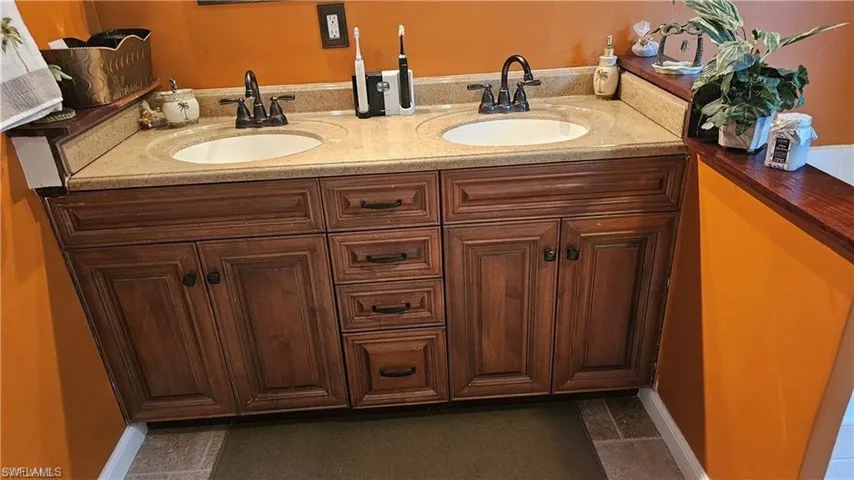 Bathroom with double vanity and baseboards
