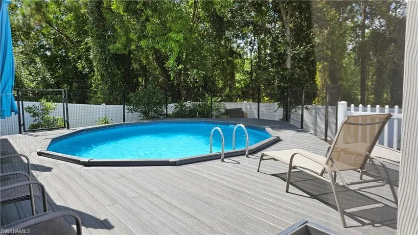 View of swimming pool featuring a deck and a fenced backyard