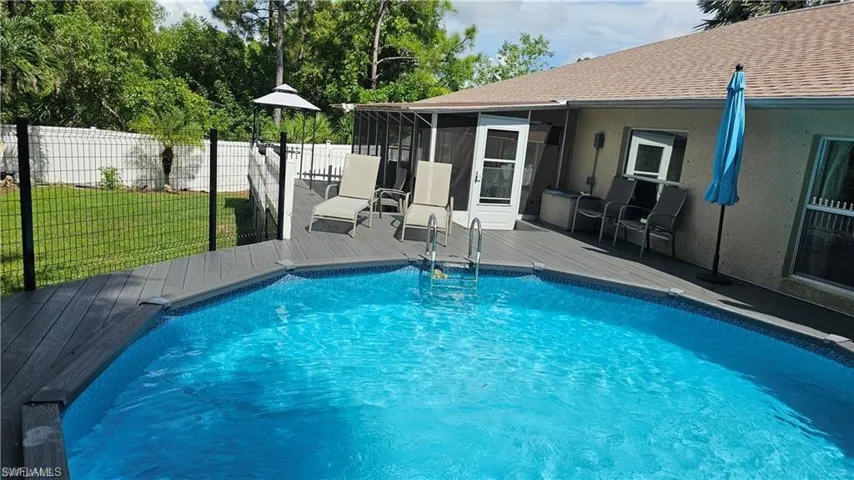 View of pool with a sunroom and a wooden deck