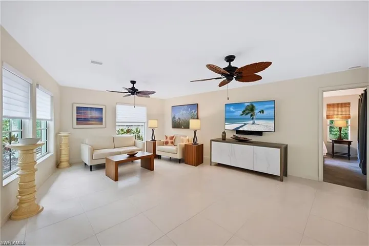 Living area featuring healthy amount of natural light, a ceiling fan, and light tile patterned floors