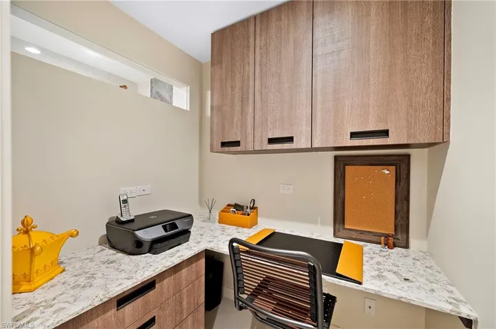 Kitchen featuring light stone countertops and built in desk