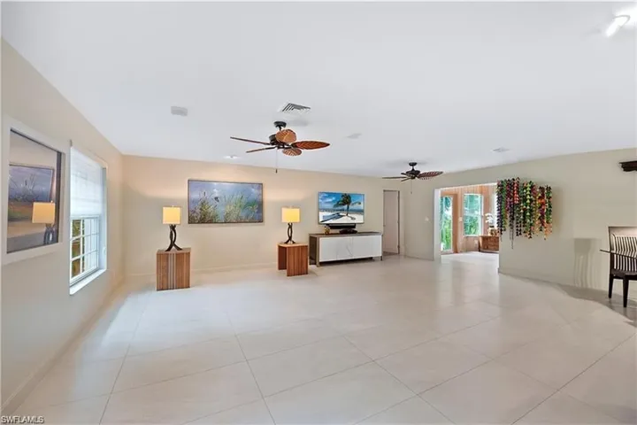 Living room with light tile patterned flooring and ceiling fan